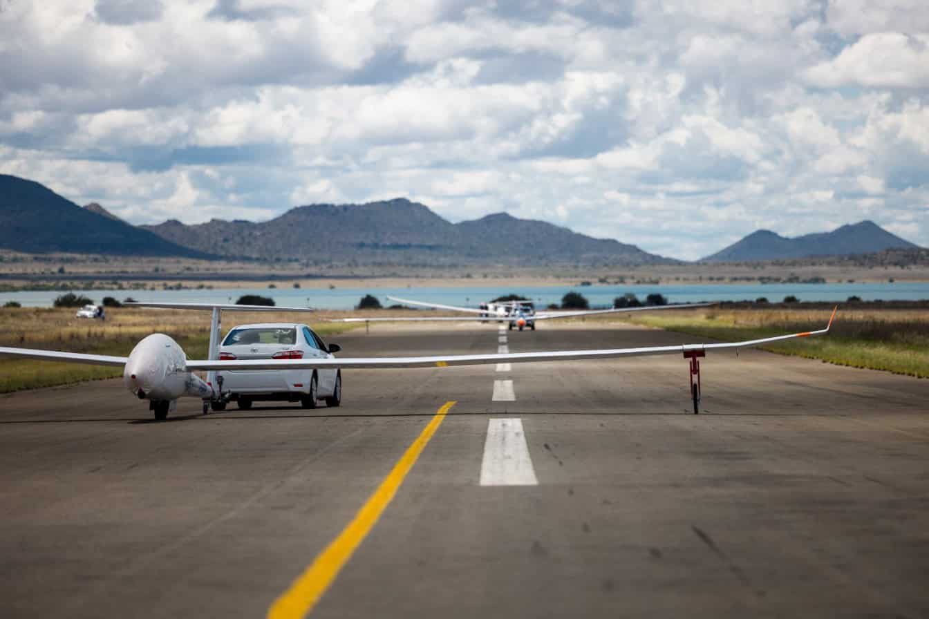 cars towing gliders on the runway of the airport
